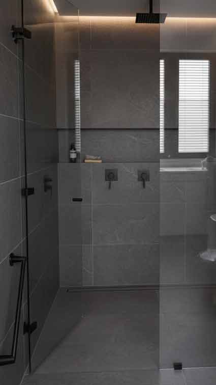 Baño moderno con puerta de vidrio batiente y fijo lateral